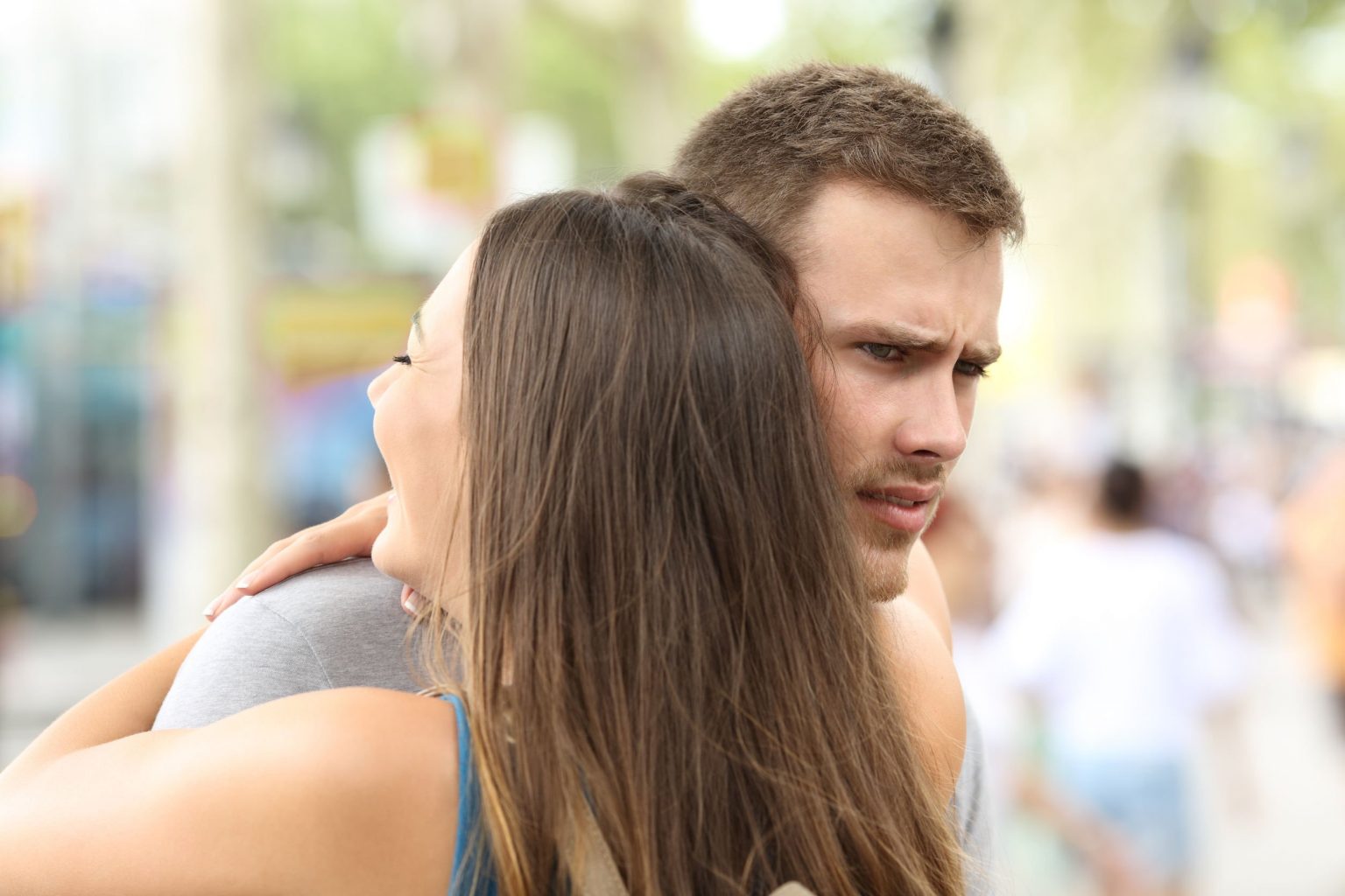 84207902 - discontent boyfriend hugging his partner on the street