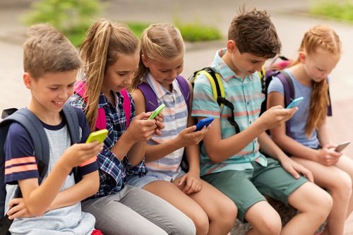 Děti a mobilní telefony. Tráví u nich příliš času, ale viníky jsou rodiče